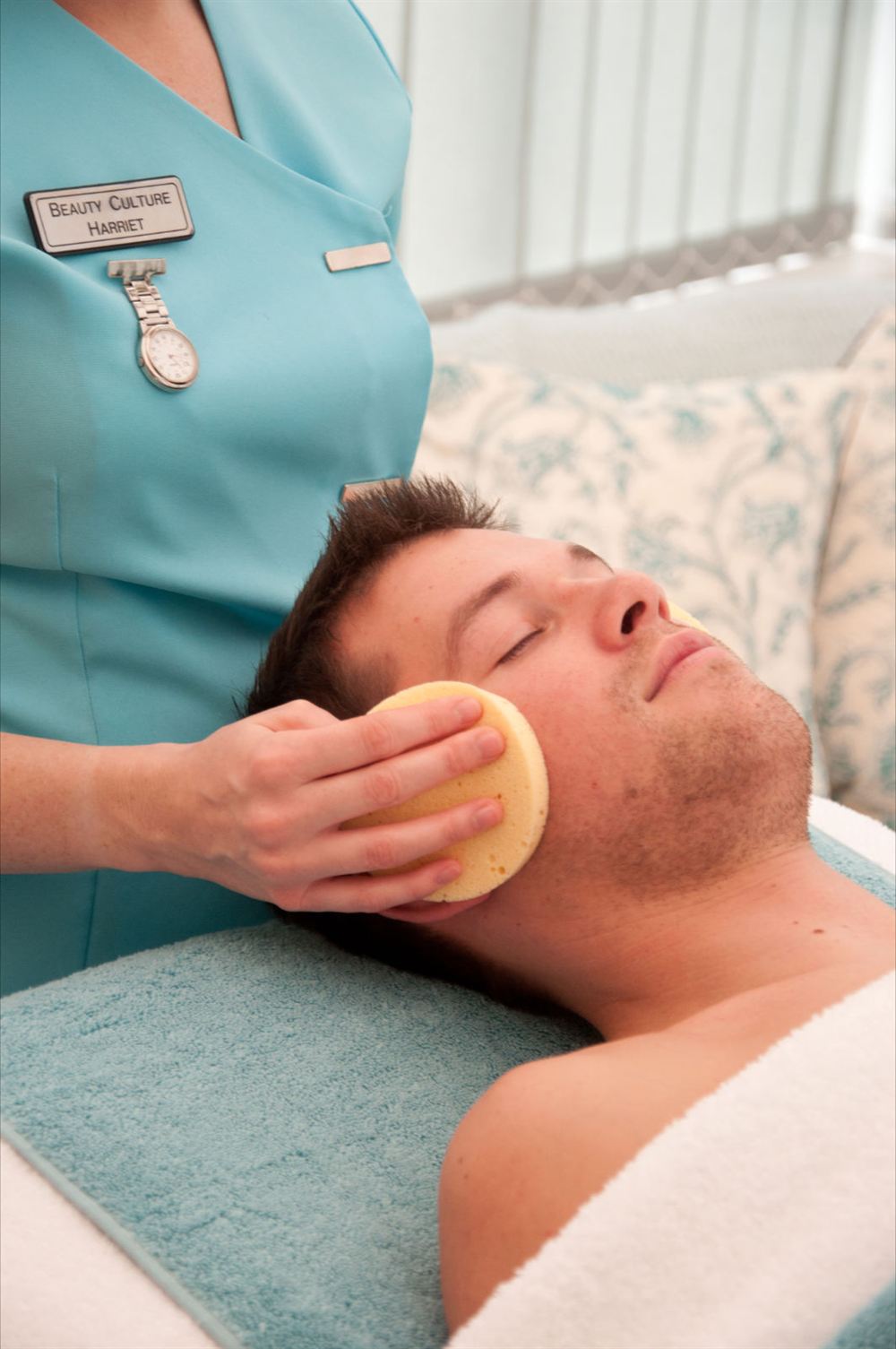 Harriet giving a male client a relaxing facial treatment